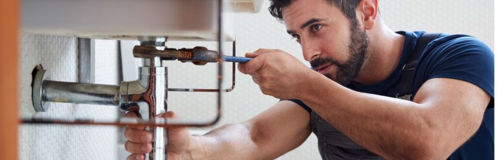A Plumber Working On a Sink