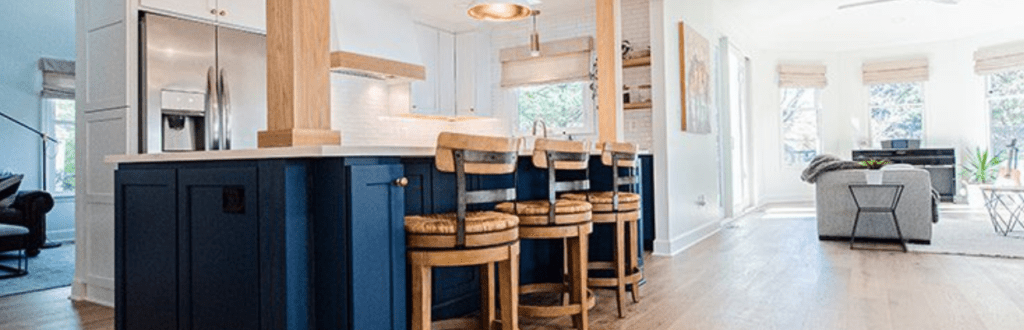 an open floor kitchen remodel with blue cabinets and wood accents 